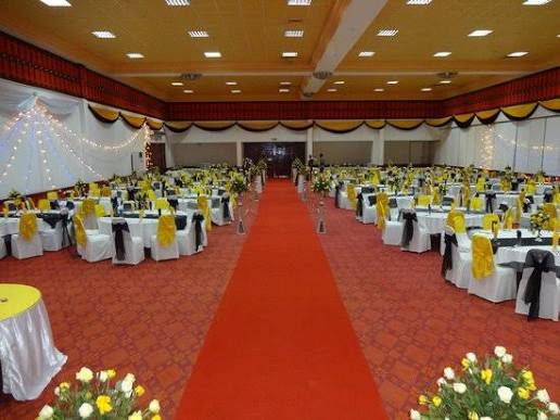 Banquet-style hall setup with gold and white décor